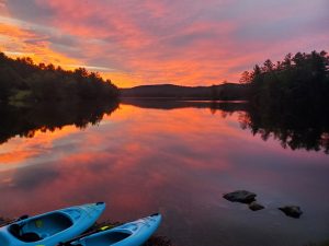 picture of sunrise over Grafton Pond with kayaks in foreground