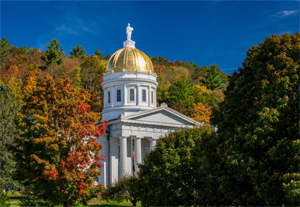 Gold leaf dome of the Vermont State House capitol building in Montpelier, Vermont. Brilliant fall colors surround the building